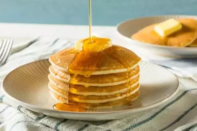 stack of pancakes covered in butter and syrup