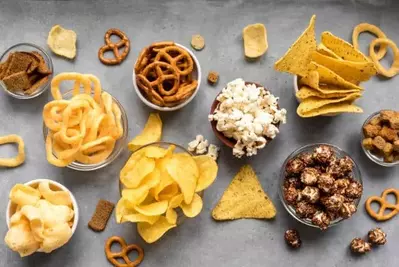 snacks in bowls including funions, chips, popcorn, pretzels, doritos, and more