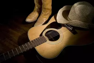 Country music kit with cowboy hat, boots, and guitar