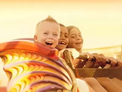 Kids on a roller coaster at sunset