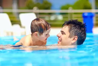Man and son in swimming pool.