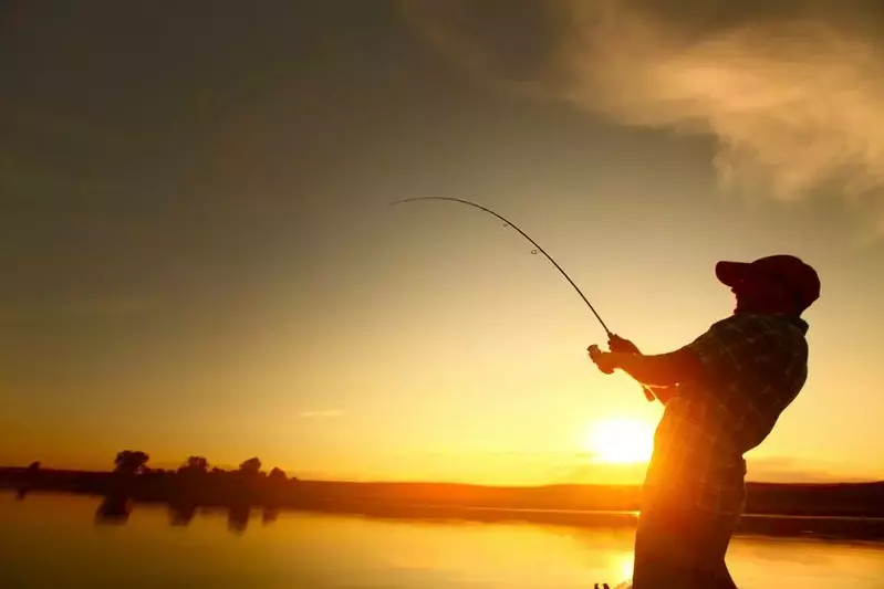 A man fishing in a river as the sun sets.